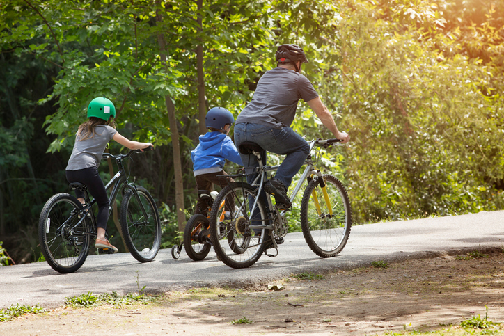 father with 2 children bike riding